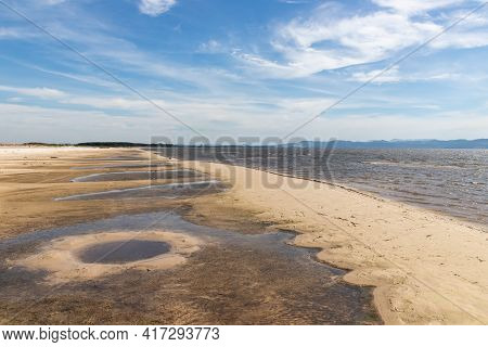 Sand And Lake With Blue Sky