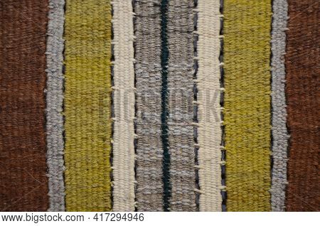 Background Of An Old Worn Carpet Sewn With Thick Threads.