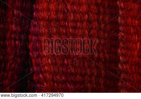 Background Of An Old Worn Carpet Sewn With Thick Threads.
