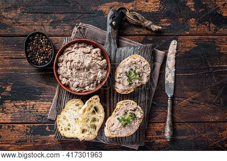Toasts With Duck Pate Rillettes De Canard On Wooden Board. Dark Wooden Background. Top View