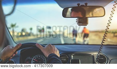 Group Of Professional Cyclists Training On Highway With Safety Escort Car. A Group Of Cyclists Follo