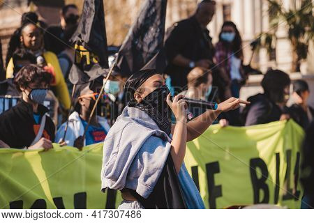 Westminster, London | Uk -  2021.04.17: Person With Microphone In Black Bandana Over Her Face Giving
