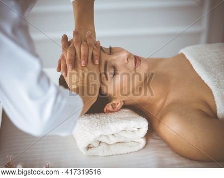 Beautiful Brunette Woman Enjoying Facial Massage With Closed Eyes Comfortable And Blissful. Relaxing