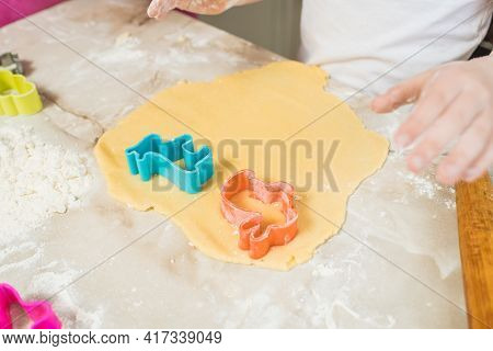 Child's Hands Squeezing Cookie Figures On The Dough. Cooking At Home