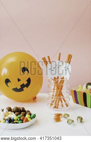 Pumpkin With Glowing Eyes And A Skull On Wooden Background. Sinister Halloween.