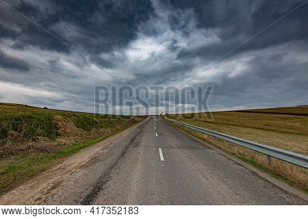 Asphalt Road Leading To The Top Of The Hill, Dramatic Gathering Stormclouds At Spring.