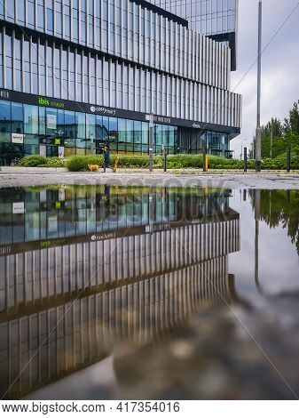 Wroclaw, Poland - June 19 2020: Facade Of Silver Tower Center Building Reflected In Puddle