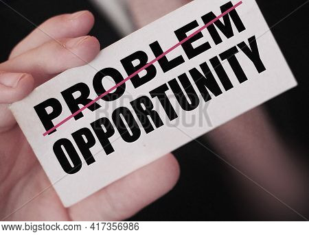 Businessman Holding A Card With Word Problem Strikeout And Opportunity. Problem Turns Into Opportuni