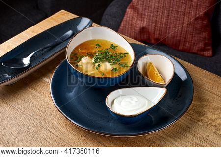 Chicken Soup With Egg Noodles On A Wooden Table.
