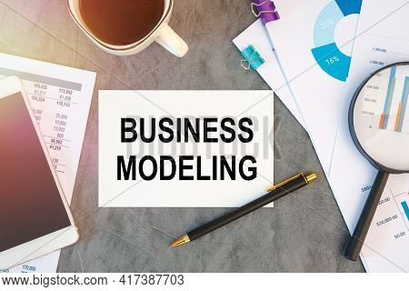 Business Modeling Is Written In A Document On The Office Desk With Office Accessories, Coffee, Diagr