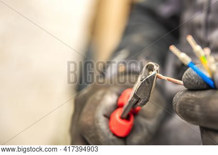 Electrician Hands Hold Wire Cutters And Close-up Of Wires. The Idea Of Repairing And Connecting Elec