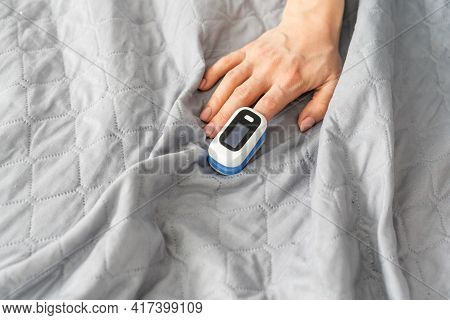 Woman Patient Using Medical Device Called Finger Pulse Oximeter. From Below, Close-up. Unrecognizabl