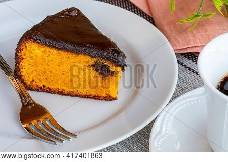 Carrot Cake With Chocolate Icing, Accompanied By A Cup Of Coffee