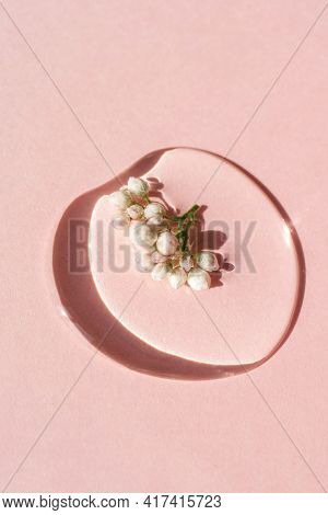 A Drop Of Cosmetic Gel With Flower On A Pink Background.