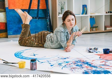Painting Hobby. Home Art. Creative Leisure. Inspired Relaxed Pensive Female Artist With Paintbrushes