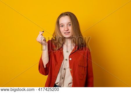 Cute Girl With Gentle Smile Makes Korean Like Sign Expresses Love To You Wears Casual Long Shirt Iso