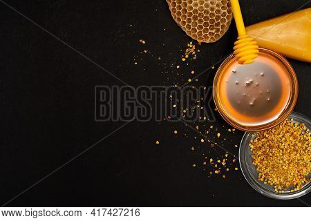 A Ladle Of Honey On The Background Of A Honeycomb Of A Bee. Honey Tidbit In A Glass Jar Honey Spoon,