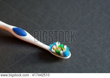 A Used Toothbrush With Disheveled Bristles On A Black Background. Replacement Of The Toothbrush, Unh