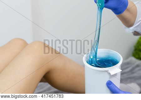 Closeup Of Female Beautician Hands Mixing Liquid Colorful Wax In Plastic Container For  Sugaring Pro