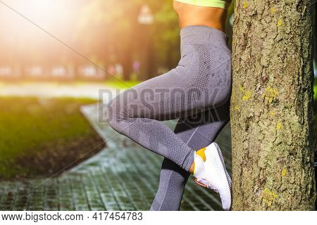 Caucasian Female During Resting Activity In Park Near Tree Outdoors At Daytime.