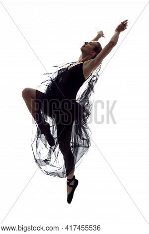 Female Ballet Dancer In Body Suit And Flying Black Dress Posing In Dance In Various Poses Against Wh