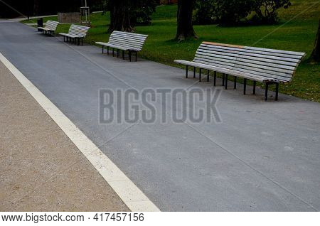 Wooden Long Park Bench With Curved Backrest Anatomical Wooden Cladding Made Of Light Wood On The Gro