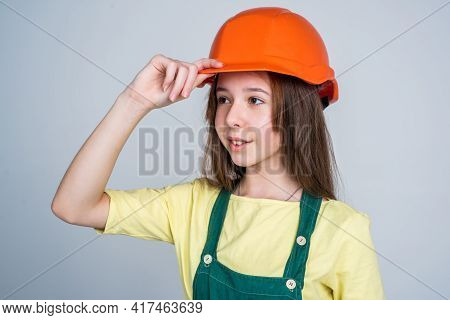 Teen Girl In Helmet And Boilersuit. Child Wear Hard Hat. Kid Builder On Construction Site. Worker En