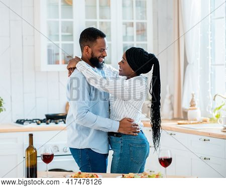 Happy Black Couple Ebracing In Kitchen While Having Date At Home