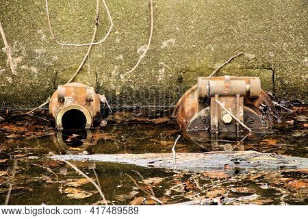 Water Inlet And Outlet Half Submerged In Dirty Canal Of A 19th Century Factory.