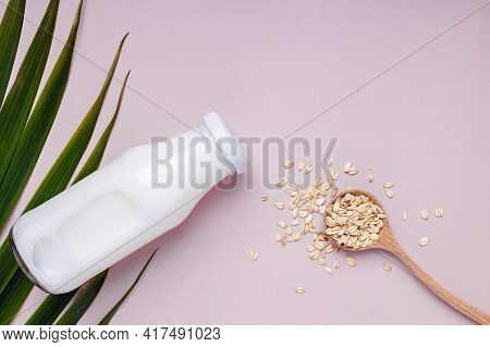 Bottle With Daity Free Oat Milk And Dry Oats In The Spoon.