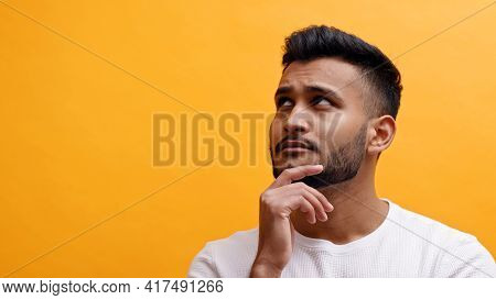 Portrait Of Handsome Adult Man Touching His Chin An Looking Up. Mixed Race Male Model With Modern Qu
