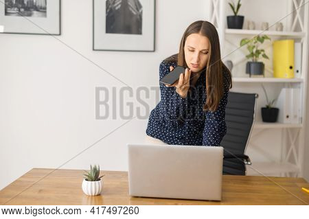 Busy Female Employee Is Using Voice Assistant On The Smartphone, Young Woman Talking In The Mic Of H