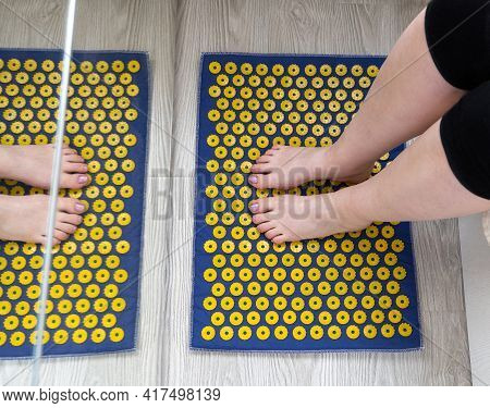 Womens Feet Stand On A Needle Mat - Foot Massage Using An Applicator Kuznetsov, Russia
