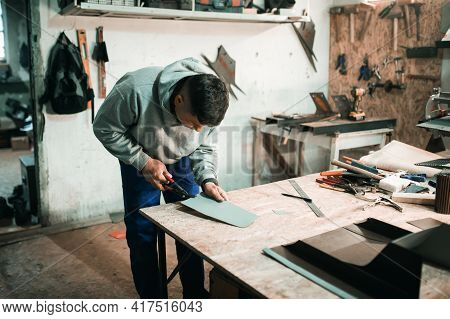 Tinsmith Blacksmith Use Hammer Working In His Workshop. Blacksmiths Workshop. Young Tinsmith In His 