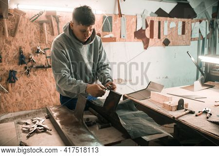 Tinsmith Blacksmith Use Hammer Working In His Workshop. Blacksmiths Workshop. Young Tinsmith In His 