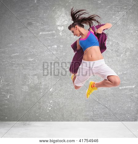 pieno di danzatrice di donna energia urlando e facendo un salto difficile