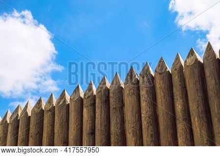Ancient Wooden Fortification Stockade Fence Of Reconstructed Fortress Under Blue Sky