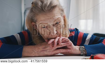 Desperate Old Woman Pensioner Looking At Small Amount Of Coins On The Table. High Quality Photo