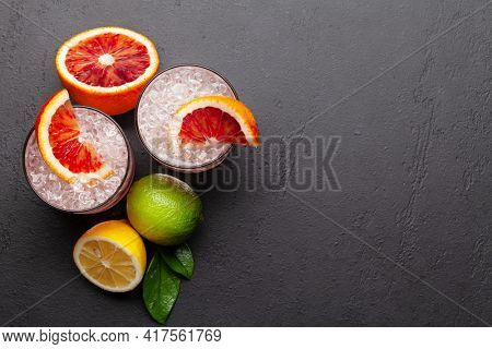 Fresh citrus lemonade with mint and crushed ice. Bood orange, lime, lemon. Top view flat lay with copy space