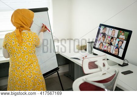 Arabic female teacher working with children online school during pandemic