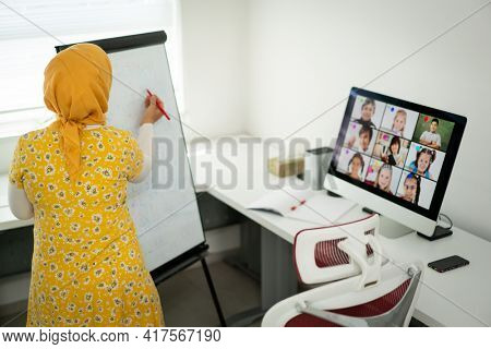 Arabic female teacher working with children online school during pandemic