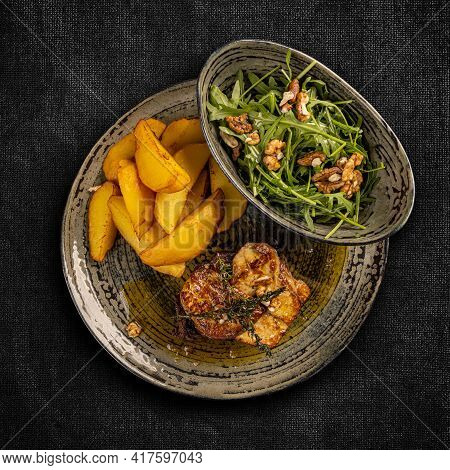 Steak With Grilled Duck Liver Garnished With Potato Wedges And Aragula, Top View