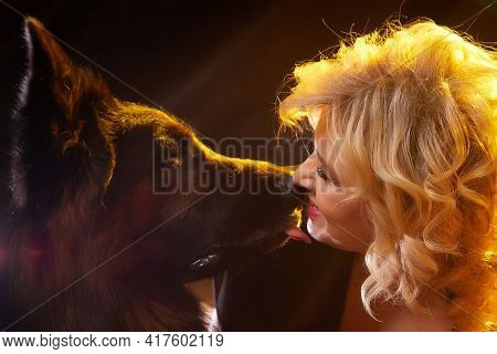 Cute Blonde Woman And Dog German Shephers Posing During Studio Photo Shot. Tender Relations And Frie