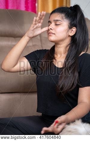 Portrait Of Young Girl In Sportswear Doing Nasal Or Nostril Breathing Exercise At Home - Concept Of 