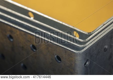 Stack Of Construction Perforated Steel Angle Brackets Close Up. Low Depth Of Field Photography