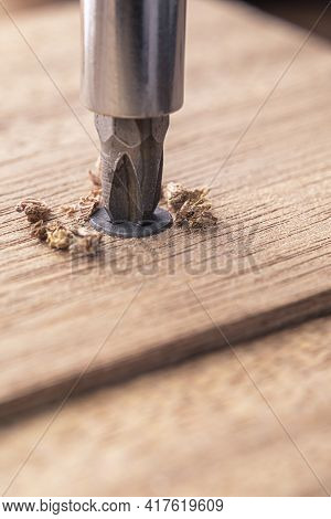 Screwdriver Screw In A Wood Oaks Plank. Self-tapping Screw For Ph2 Bit. Screws Macro Photo. Construc