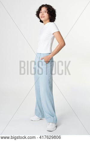 Woman in white tee and blue loose pants minimal fashion