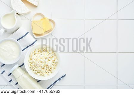 Glass Of Milk, Cottage Cheese, Ricotta, Sour Cream, Cheese, Camembert And Butter On White Table Back