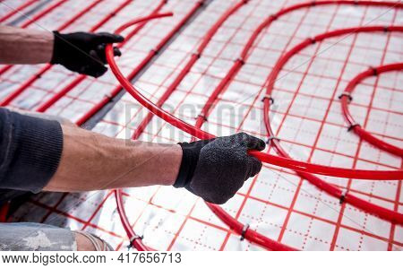 Pipefitter Install System Of Underfloor Heating System At Home