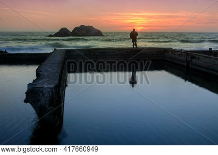 A Man Standing On Ruins Of Sutro Baths And Watching The Sunset. San Francisco, California, Usa.